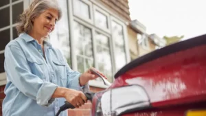 Mujer de mediana edad cargando un coche eléctrico